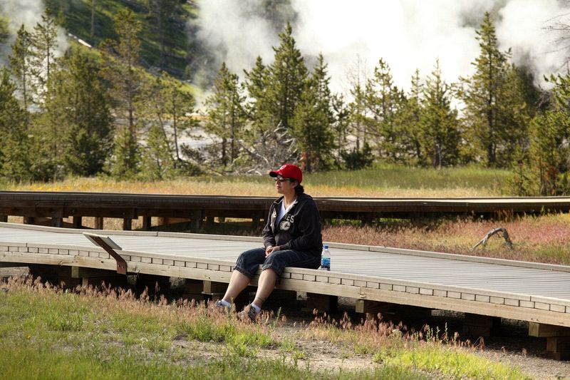 Walking around the geyser fields at Old Faithful - Michelle taking in the steam.
